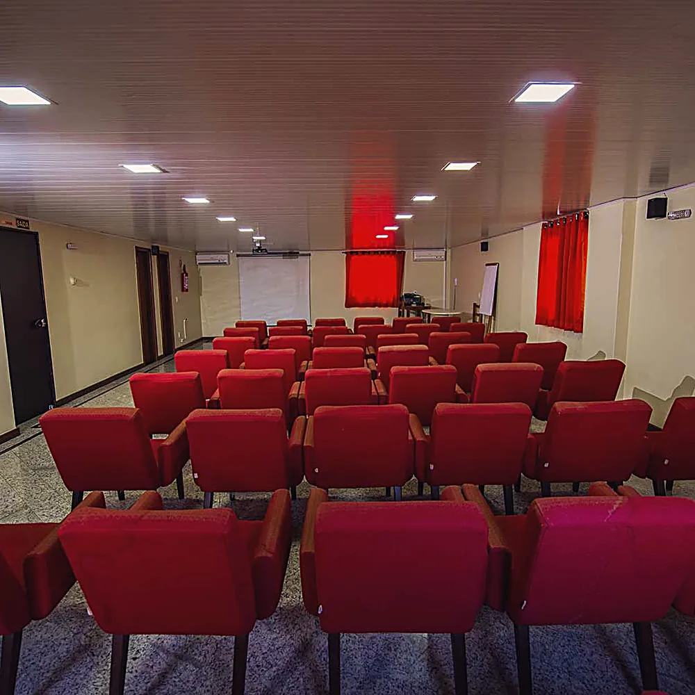 Auditório para eventos do Hotel Rinkão em Cachoeiro de Itapemirim, com poltronas e projeção