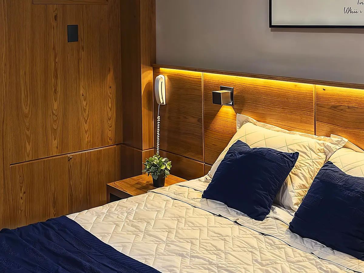 Quarto Premium reformado do Hotel Rinkão em Cachoeiro de Itapemirim, com cabeceira em LED e roupa de cama com detalhes em azul-marinho