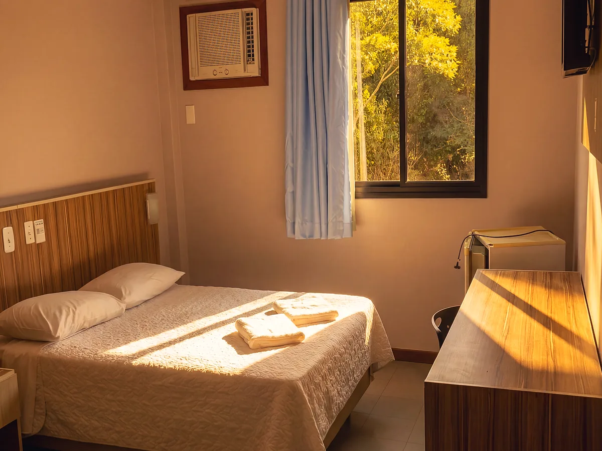 Quarto Standard do Hotel Rinkão em Cachoeiro de Itapemirim, com cama de casal, ar-condicionado e mesa de trabalho